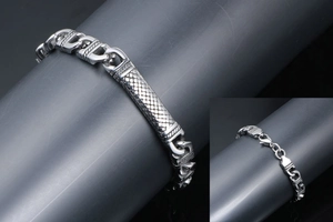 Detail of vintage silver stainless steel cuban chain bracelet with snakeskin texture