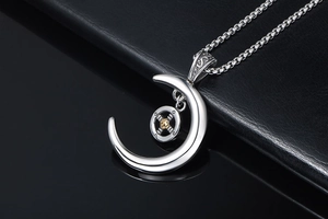 Vue macro d'un pendentif demi-lune avec relief de croix dorée sur fond de cuir noir