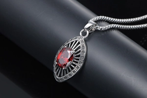 Macro view of water-drop ruby zircon pendant with retro mesh steel chain detail