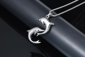 Detailed macro view of silver dolphin pendant featuring a mirror-polished finish