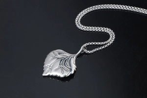 Macro view of silver leaf pendant showing detailed vein texture and box chain detail