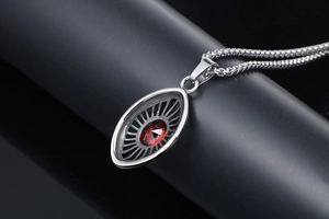 Macro shot of silver gothic teardrop pendant with a radiant red ruby gemstone and metal chain