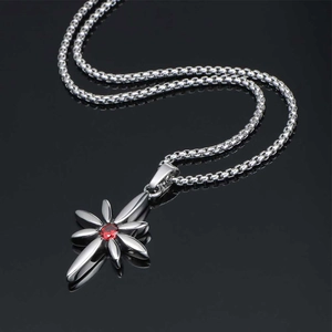 Punk style titanium steel necklace with starburst ruby pendant on reflective black surface