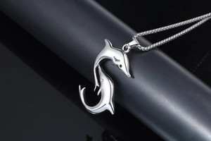 Macro shot of polished silver double dolphin pendant necklace with a sleek box chain