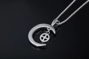 Détail du pendentif lune argentée avec anneau texturé sur une chaîne en acier poli