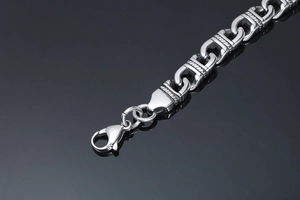 Macro shot of polished stainless steel totem bracelet with heavy lobster clasp closure