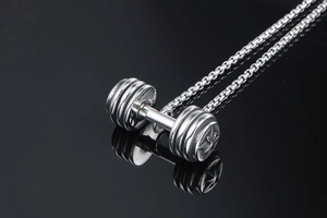 Dettaglio macro del ciondolo a manubrio argento con rilievo a stella e catena box
