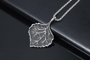 Detailed macro view of an oxidized silver leaf pendant with intricate vein textures