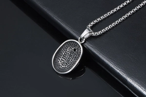 Macro view showing the honeycomb textured back of the silver oval steel pendant