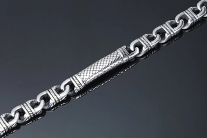 Close-up of industrial punk stainless steel bracelet with engraved textured metal links
