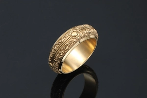 Detailed macro view of vintage gold steel ring featuring ornate engraved scroll patterns
