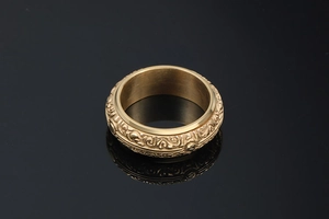 Macro view of vintage gold-plated steel ring with intricate embossed astronomical patterns