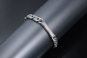 Macro view of stainless steel totem bracelet with embossed diamond grid texture