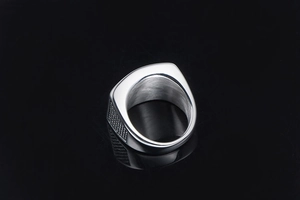 Macro shot of silver titanium steel signet ring for men featuring cross grid side patterns