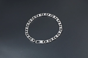 Macro detail of silver stainless steel chain bracelet with H-link design and lobster clasp