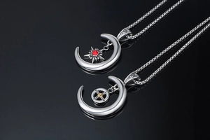 Gros plan de pendentifs lune avec étoile rouge et roue dorée sur une surface noire lisse