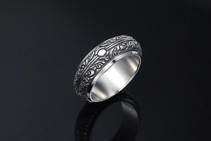 Detail of vintage gothic steel ring featuring intricate scroll pattern and antique finish