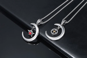 Détail de pendentifs en croissant de lune avec étoile rouge et engrenage doré sur cuir