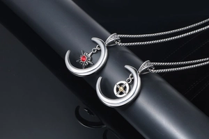 Gros plan de pendentifs lune en argent avec étoile rouge et détails de croix dorée