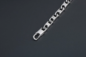 Close-up of silver steel chain link bracelet with secure lobster clasp closure