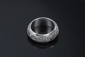 Macro detail of men's retro steel ring featuring intricate engraved floral patterns