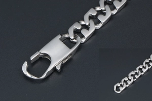 Close-up of a polished silver titanium steel Cuban chain bracelet with square clasp
