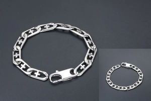 Detail of silver titanium steel chain bracelet featuring hollow cross links and lobster clasp