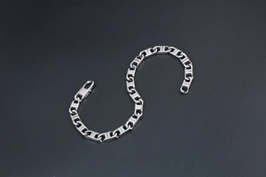 Detail shot of the rectangular link silver metal chain bracelet with a lobster clasp closure