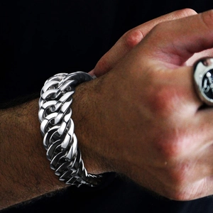 Men's bold braided cuban link bracelet in polished titanium steel on model wrist
