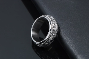 Macro detail of vintage floral engraving on silver stainless steel wide ring band