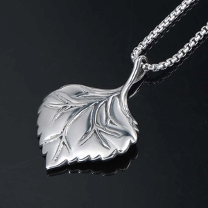 Silver leaf pendant necklace with realistic leaf vein texture on a black reflective background