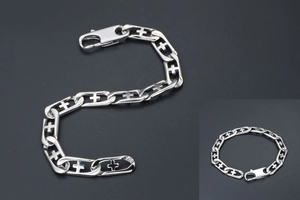 Macro shot of silver stainless steel chain bracelet featuring hollow cross link design