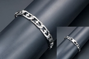 Close-up of punk style titanium steel bracelet featuring cross cut-out links and lobster clasp