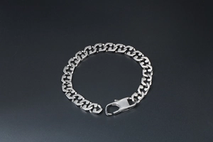 Close-up of a minimalist silver titanium steel bracelet with large lobster clasp