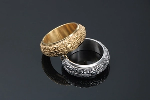 Detailed view of vintage embossed gold and silver titanium rings with floral patterns