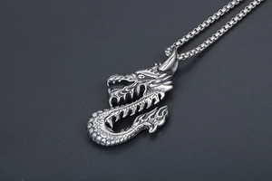Gros plan du pendentif tête de dragon en acier titane rétro avec finition argentée texturée