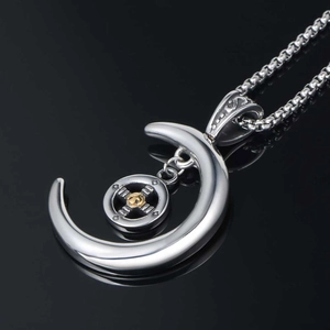 Collier avec pendentif croissant de lune argenté et détail croix dorée sur chaîne