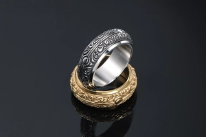 Macro view of stacked silver and gold vintage rings with intricate floral reliefs