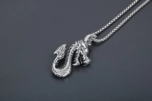 Vue détaillée d'un pendentif dragon vintage avec écailles ciselées sur chaîne box