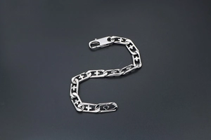 Detail of silver titanium steel bracelet featuring punk cross links and a lobster clasp