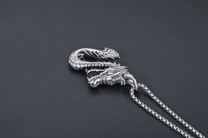 Détail de près du pendentif dragon en argent montrant les écailles et l'artisanat