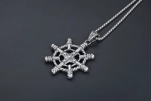 Detailed close-up of a vintage silver nautical ship wheel pendant on a round bead chain