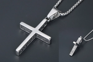 Vue détaillée du pendentif croix en argent avec petits motifs de croix gravés sur le côté