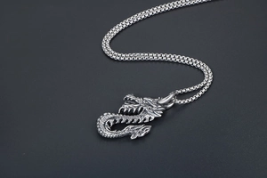 Gros plan détaillé d'un pendentif dragon en argent avec écailles et gravures vintage