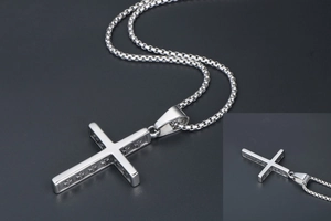 Détail d'un pendentif croix vintage avec relief latéral sur une chaîne maille box