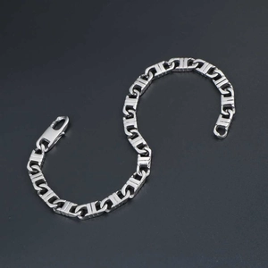 Minimalist silver chain bracelet with industrial links on a matte black surface