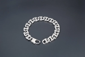 Détail d'un bracelet gourmette lourd en acier inoxydable avec accents gravés de trois points