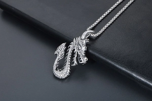 Gros plan détaillé d'un pendentif dragon en argent avec des écailles sur fond de cuir noir