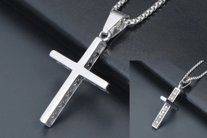 Détail du pendentif croix en argent montrant la surface polie et les motifs gravés