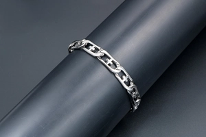 Macro detail of silver stainless steel chain bracelet with hollow cross pattern links
